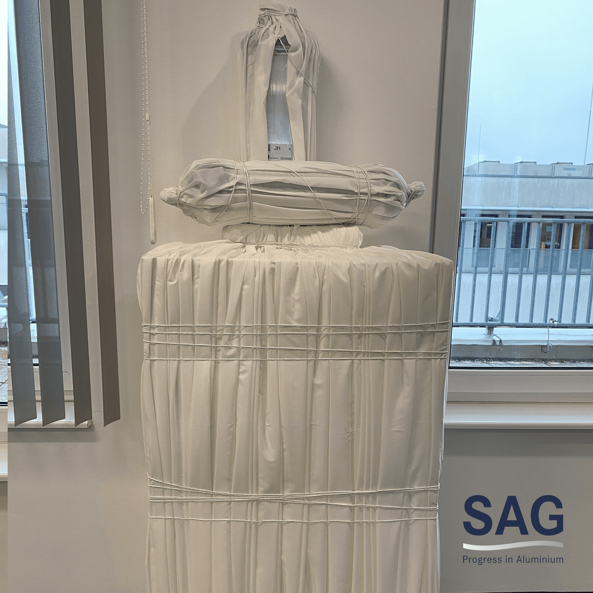 Bílý závěs před bílou plochou, zasazený do kontextu chodníku CANCOM smART Walk, symbolizuje čistotu a jednoduchost digitalizace.