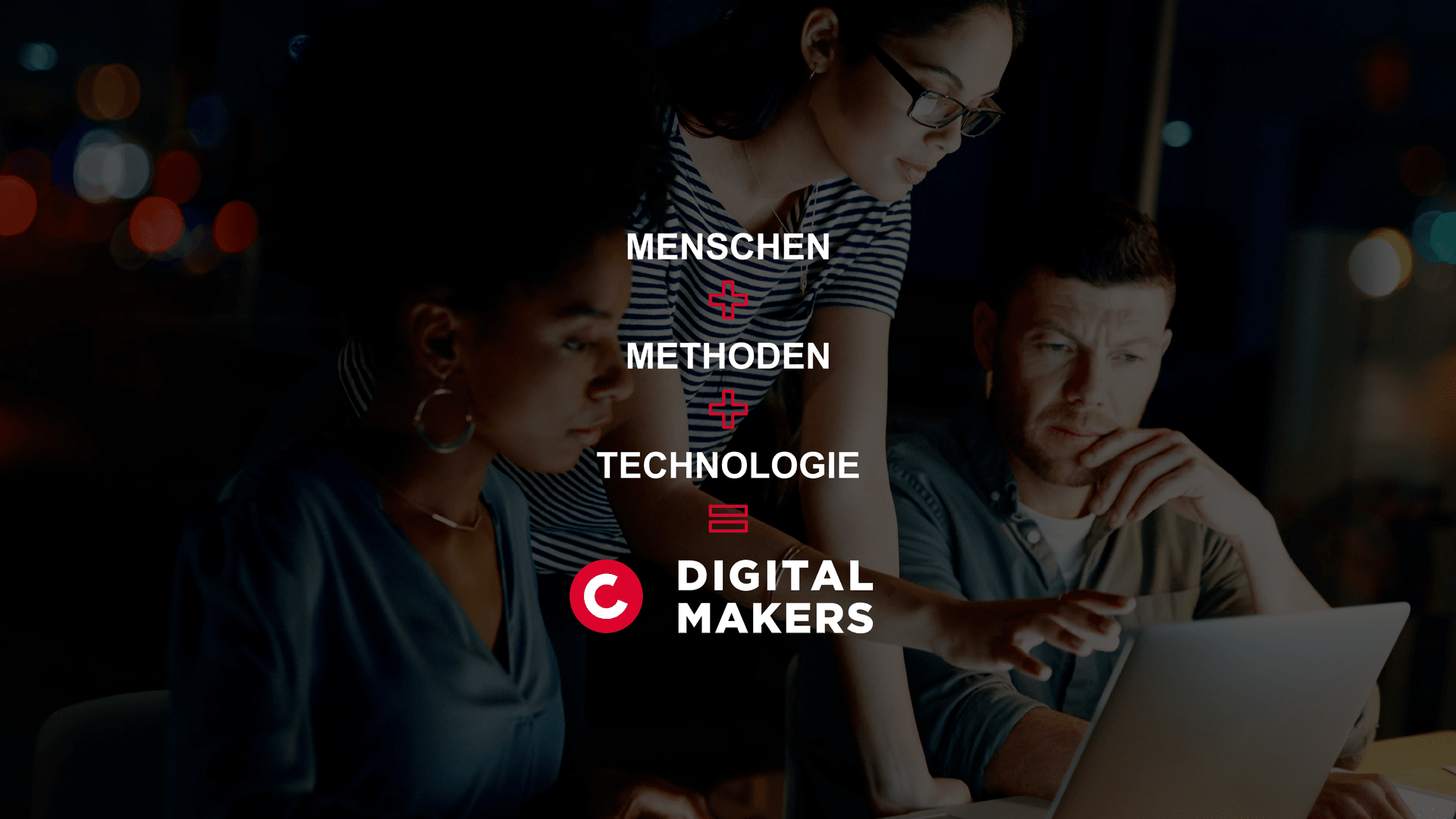 Skupina zaměstnanců, kteří se společně dívají na displej notebooku pro vývoj digitálních řešení.